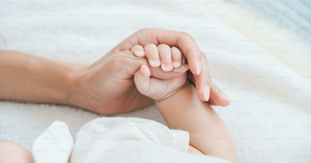 Main d'enfant tenue par un adulte - accompagner un enfant en deuil