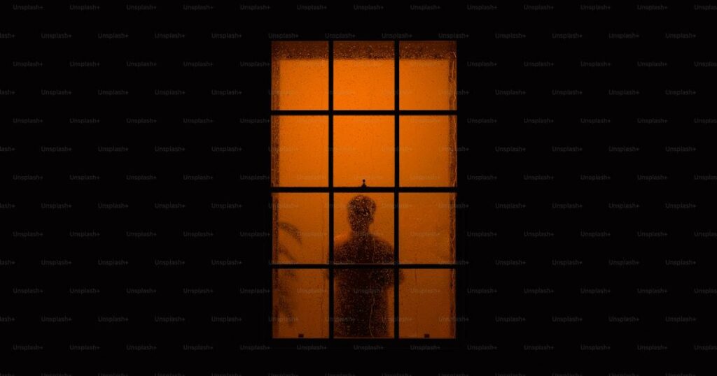 Silhouette pensive devant une fenetre - deuil d'un proche